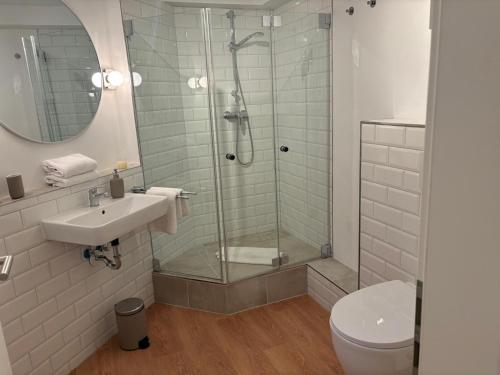 a bathroom with a shower and a sink and a toilet at Heefkant Haus Heefkant, HK 03 in Rantum