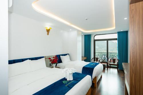 a hotel room with two beds and a balcony at ANH ANH HOTEL in Bắc Hà