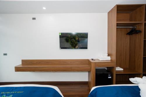 a room with two beds and a desk at ANH ANH HOTEL in Bắc Hà