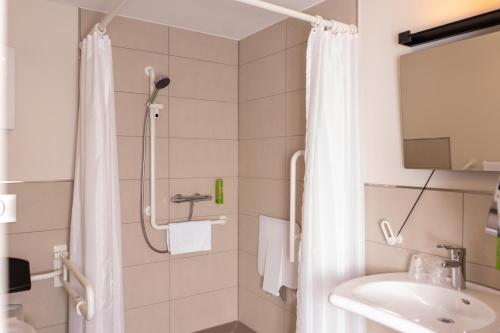 a bathroom with a shower and a sink at Hotel Neue Mitte in Schlüchtern