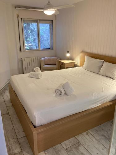 a bedroom with a large white bed with a chair at Beachfront Apartment with Sea Views & Private Parking in San Pol de Mar