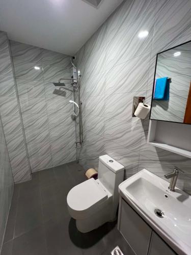 a bathroom with a white toilet and a sink at LUNA by LCB Apartelle and Resort Tagaytay in Tagaytay