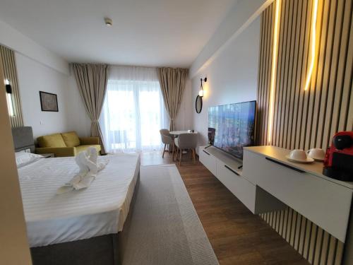 a hotel room with a bed and a flat screen tv at Sunset Beach Studio by Blaxy Resort Olimp in Olimp