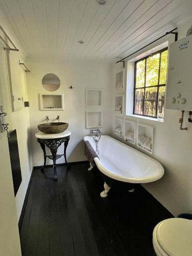 a white bathroom with a tub and a sink at Field Cabin in Rosendal