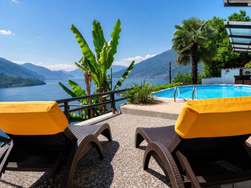 two chairs and a swimming pool with mountains in the background at Asti in Gravedona