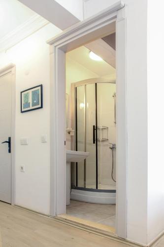 a bathroom with a shower and a glass door at Bozcaada Su otel in Bozcaada