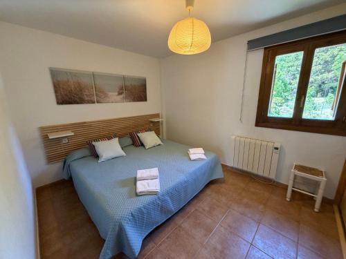 ein Schlafzimmer mit einem Bett, auf dem zwei Handtücher liegen in der Unterkunft Escuacho in Escarrilla