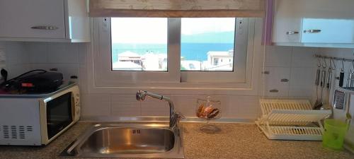 a kitchen counter with a sink and a window at Local Paradise Xilokastro in Xylokastro