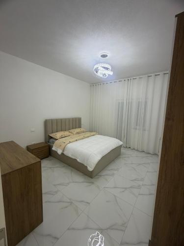 a bedroom with a bed and a large tiled floor at Alison Guest House in Durrës