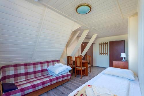 a room with two beds and a couch and a table at Ośrodek Wypoczynkowy AS PIK dawniej Hotel AS PIK in Niechorze