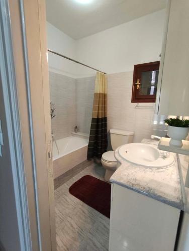 a bathroom with a sink and a toilet and a tub at Kalymnos Sea View Villa in Kalymnos