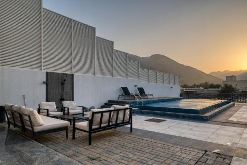 a building with a pool with chairs and a table at 3BR villa BBQ Pool and Maidroom near diving center Dana Island in Sharm