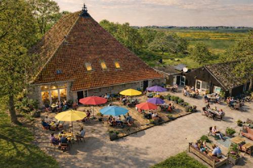 an overhead view of a building with tables and umbrellas at Houseboats Pean-buiten Weidum in Weidum