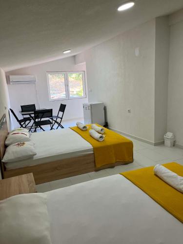 a bedroom with two beds and a table and chairs at Villa Utopia in Star Dojran