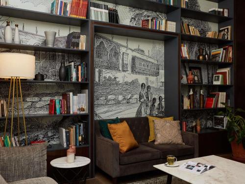 a living room with a couch and book shelves with books at Manto Hotel Lima - MGallery Collection in Lima