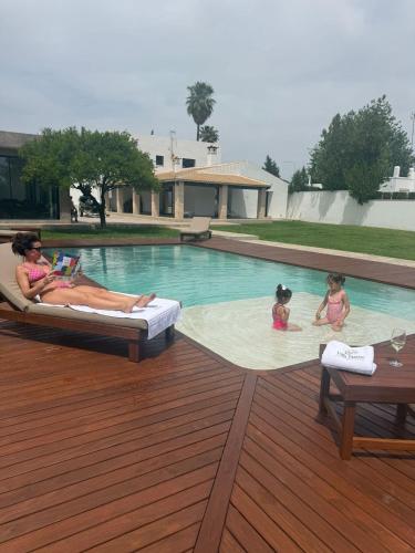 a woman and two children swimming in a swimming pool at Villa Paraíso in Seville