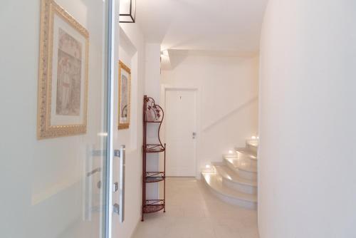 a hallway with white walls and a staircase with silver plates at Residenza Isotta in Rimini