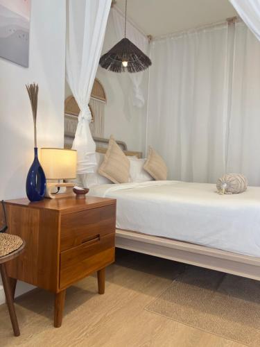 a bedroom with two beds and a table with a lamp at Nomad Beach House, Koh Lanta in Ko Lanta