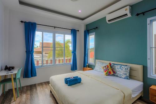 a bedroom with two beds with blue walls and a window at Villa Paradise a unique cocoon in Bophut