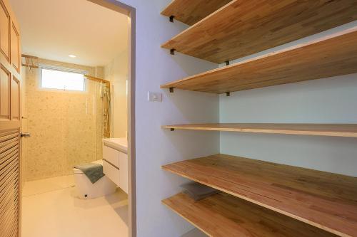a bathroom with wooden shelves and a toilet at Villa Paradise a unique cocoon in Bophut
