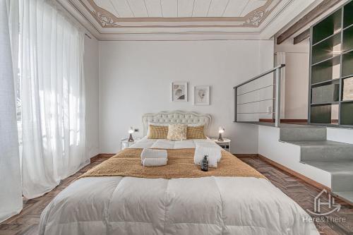 a white bedroom with a large bed with two pillows at SweetWater Villa - Pool - Solarium - Smart TV in Savona
