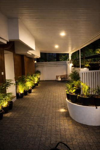 a patio with a row of potted plants and lights at 88 villaggio Edappally in Edappally