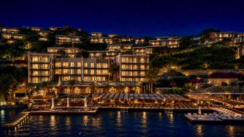 a large building on the side of a river at night at Mare Deluxe Residences & Villas in Bodrum City