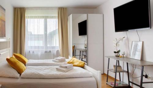a bedroom with two beds and a television on the wall at Seelina in Perach