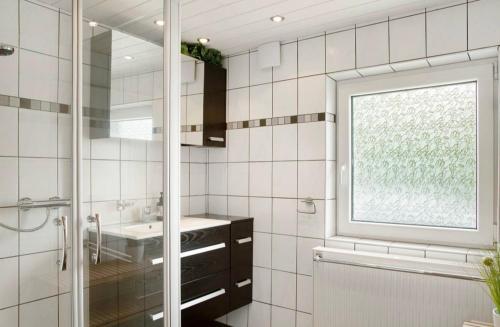 a bathroom with a shower and a sink and a window at Seelina in Perach