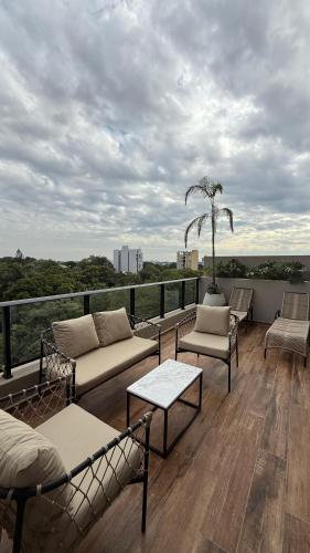 a patio with couches and chairs on a balcony at Divina Tower Apart Hotel in Asunción
