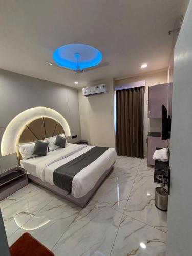 a bedroom with a large bed with a blue ceiling at Hotel Planet Lake in Ahmedabad