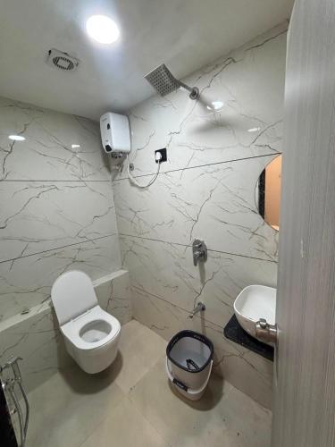 a bathroom with a toilet and a sink at Hotel Planet Lake in Ahmedabad