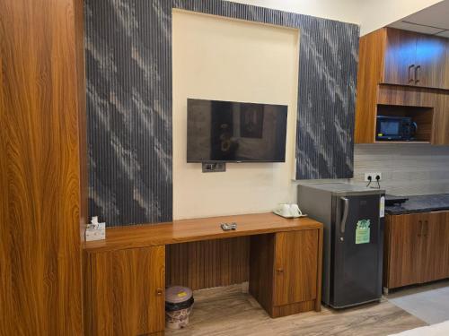 a kitchen with a desk and a refrigerator at Siri Stays in Greater Noida