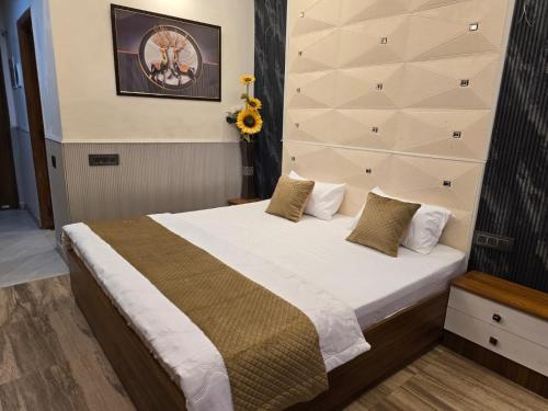 a bedroom with a large bed with white sheets and pillows at Siri Stays in Greater Noida