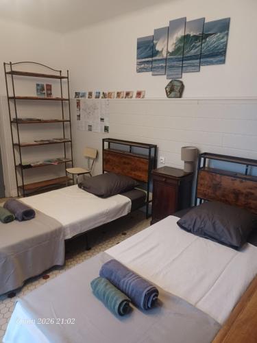 a room with two beds and a shelf at La madeleine in Caussade