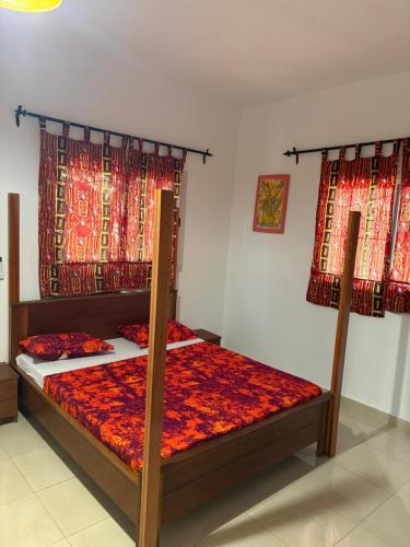 a bedroom with two bunk beds with red curtains at Villa Clémence in Mbour