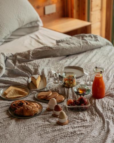 a breakfast table with food and eggs on a bed at Chalet Noèr in Ledro