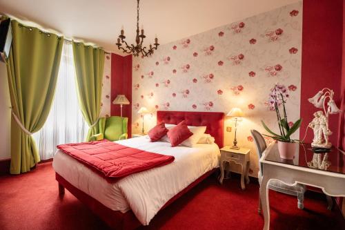 a bedroom with a large bed and a table with a desk at Le Trianon in Étel