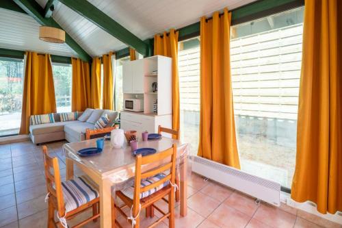 a living room with a table and chairs and a couch at House with small garden and shared pool in Moliets-et-Maa