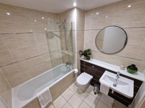 a bathroom with a tub and a sink and a toilet at Halton Hideaway in Halton