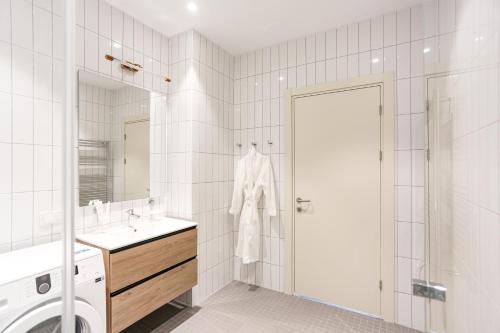 a white bathroom with a washing machine and a sink at Green Cape Botanico in Batumi