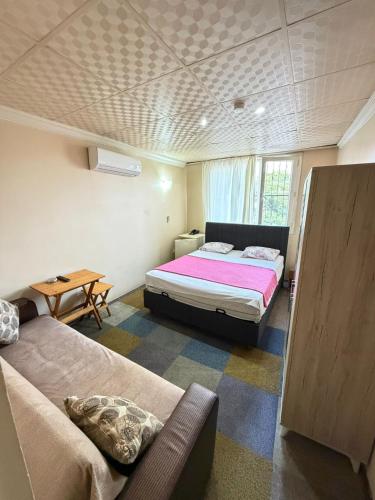 a bedroom with a bed and a couch and a table at Evim Butik Otel in Seyhan