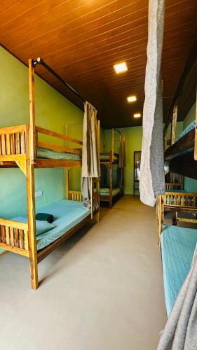 a room with three bunk beds in a house at Hangten's Surf Skate Hostel in Arugam Bay