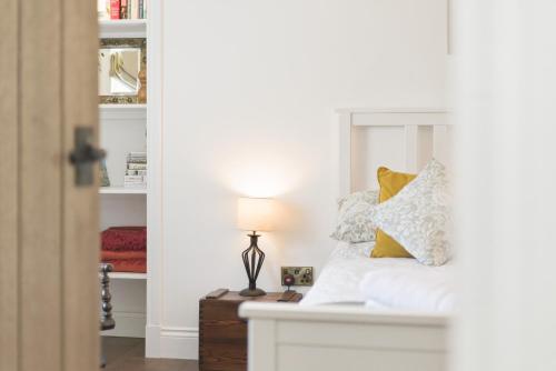 a bedroom with a bed with a lamp on a table at 20 Applegrove in Monifieth