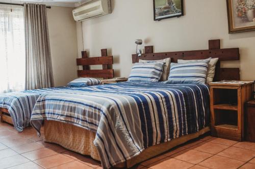 a bedroom with a bed with a blue and white blanket at Charming Self Catering Apartment in Phalaborwa