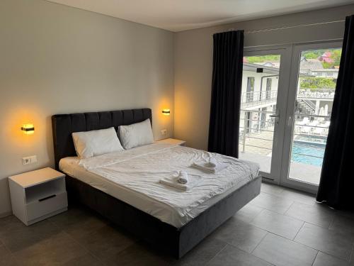 a bedroom with a bed and a large window at Hotel Elena Solotvino in Solotvyno