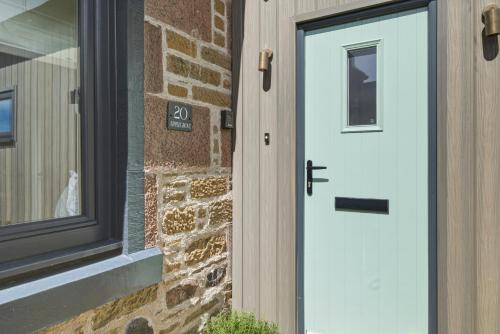 a white door on the side of a brick building at 20 Applegrove in Monifieth