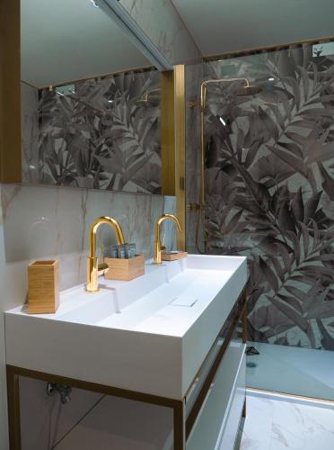 a bathroom with a sink and two faucets at Cappuccina Country Resort in San Gimignano