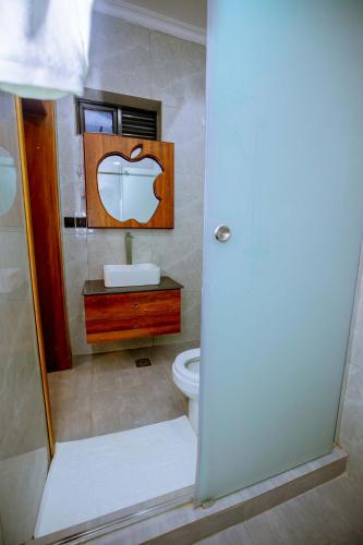 a bathroom with a toilet and a sink and a mirror at The Moon Apartment in Kigali