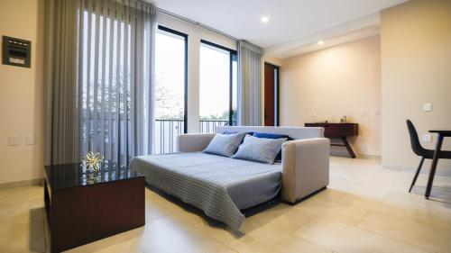 a living room with a couch and some windows at Casa las Castellanos in Tlalixtac de Cabrera